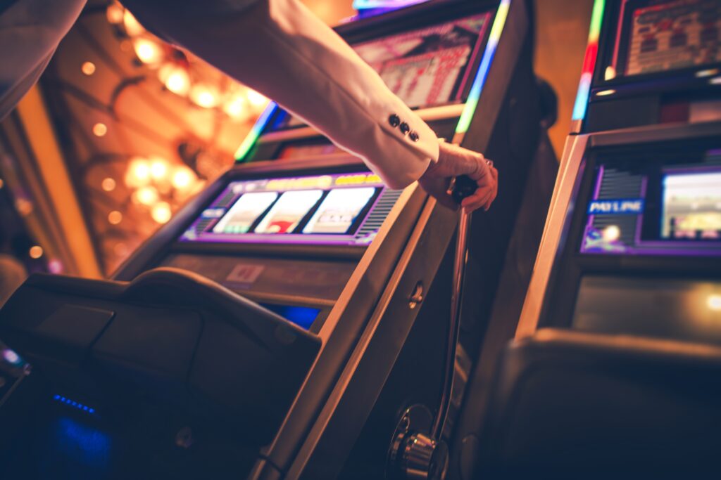 A photo of a person playing a slot machine in a casino.