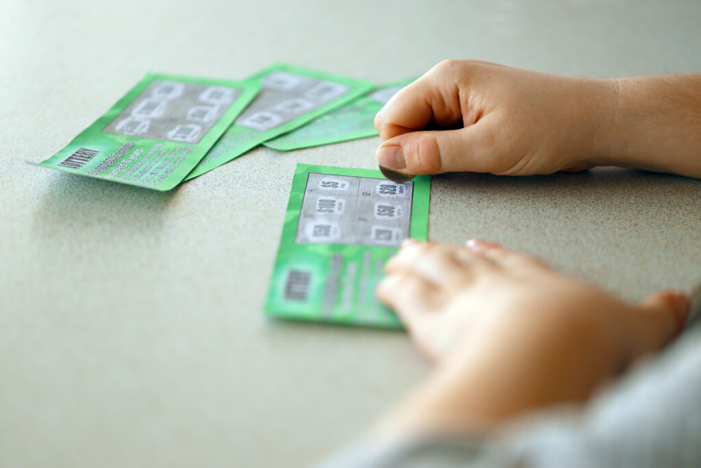 A photo of a person using a coin to scratch off a scratch card.