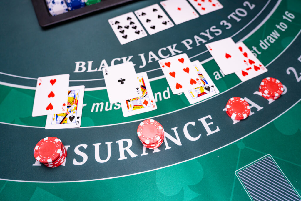 A photo of playing cards and casino chips on a blackjack table.