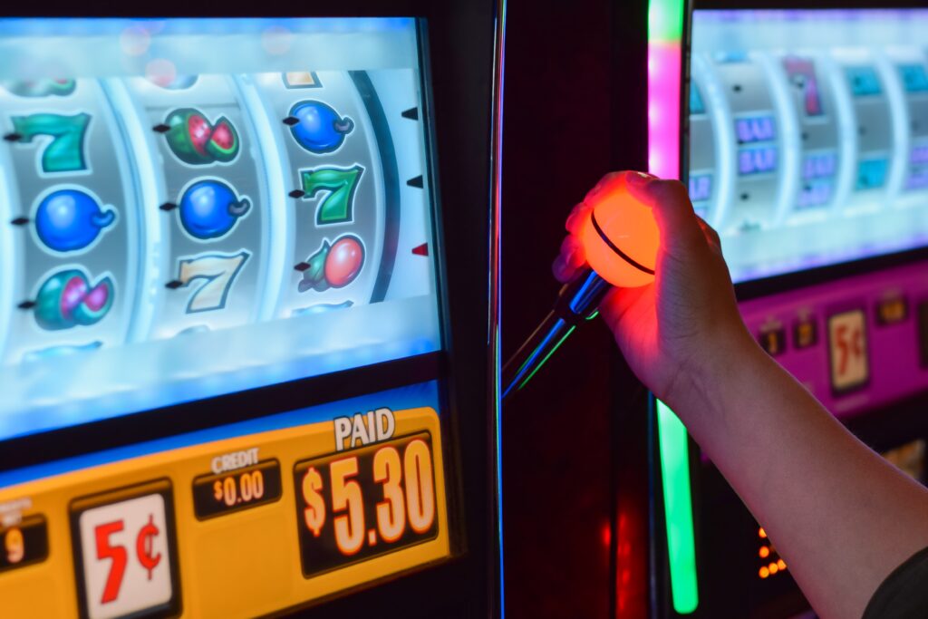 A photo of a person pulling the lever on a slot machine.