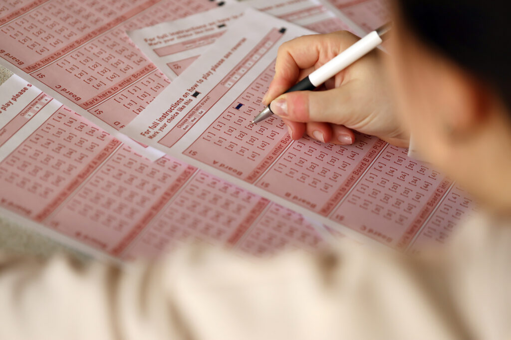 A photo of a person filling out a lottery ticket.