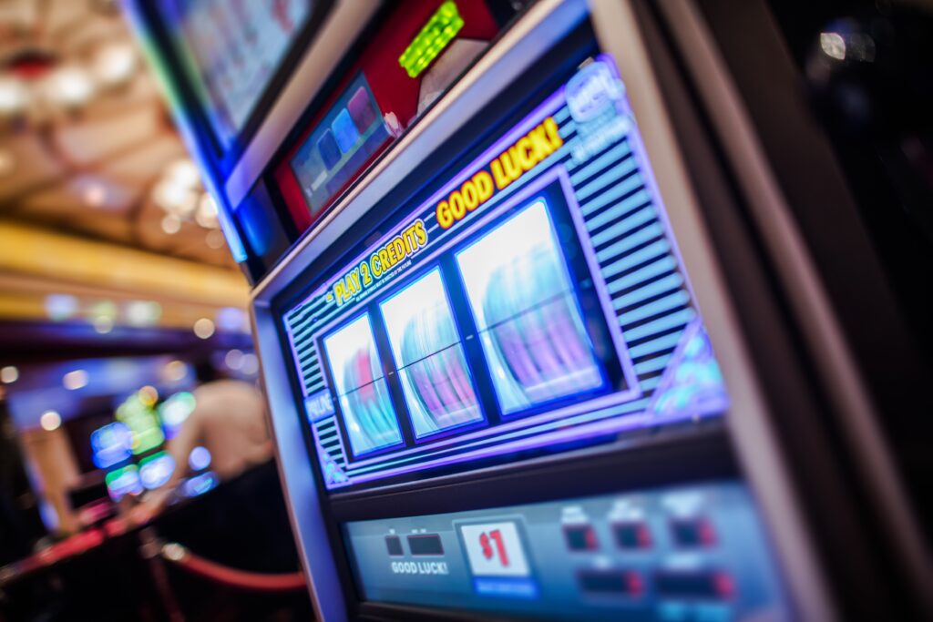 A photo of a slot machine in a casino with spinning reels.