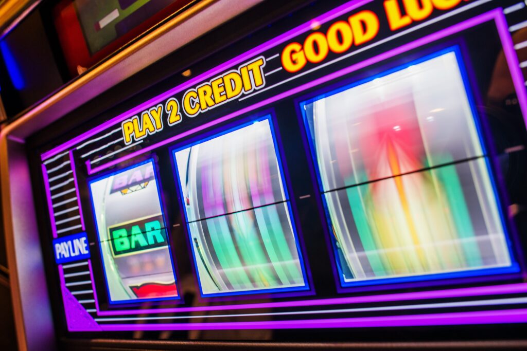 A photo of a slot machine in a casino with spinning reels.