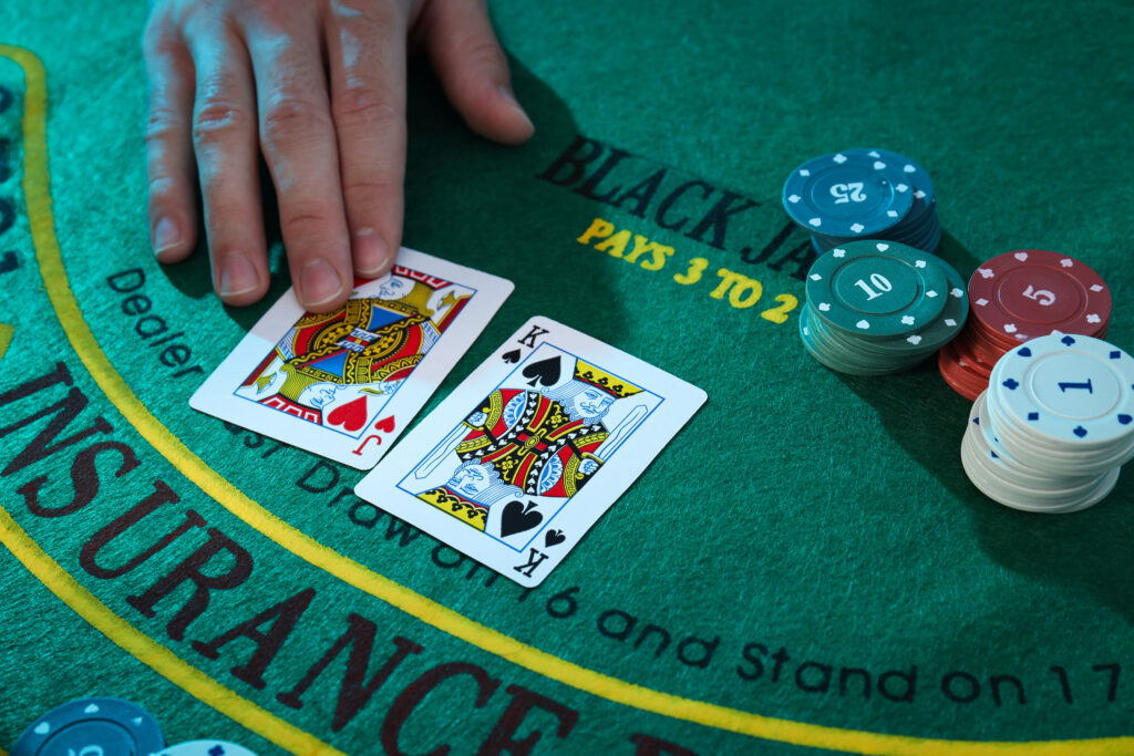 A photo of two face cards on a blackjack table next to stacks of casino chips.