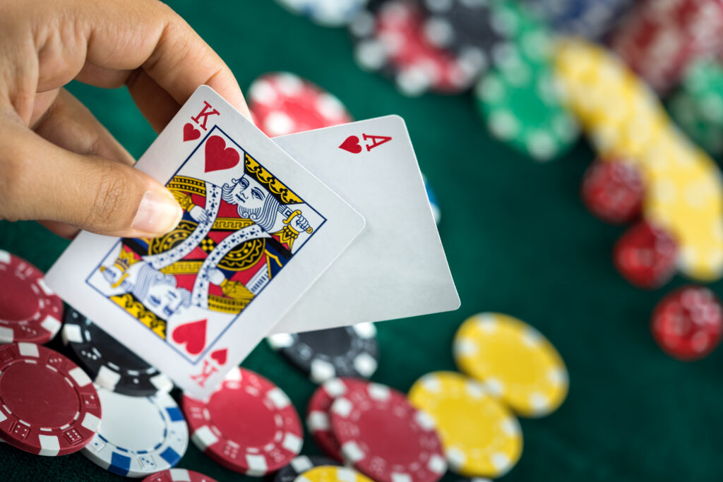A photo of a person holding the King and Ace of Hearts, which is a classed as a 'Blackjack'.