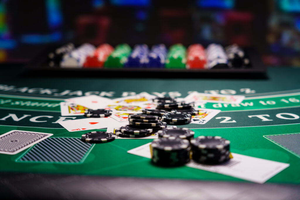 Close up of stacks of casino chips and playing cards on a blackjack table in a casino.