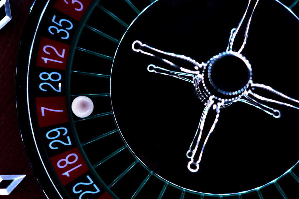 Close up of a roulette wheel with the ball on the red 7 pocket.