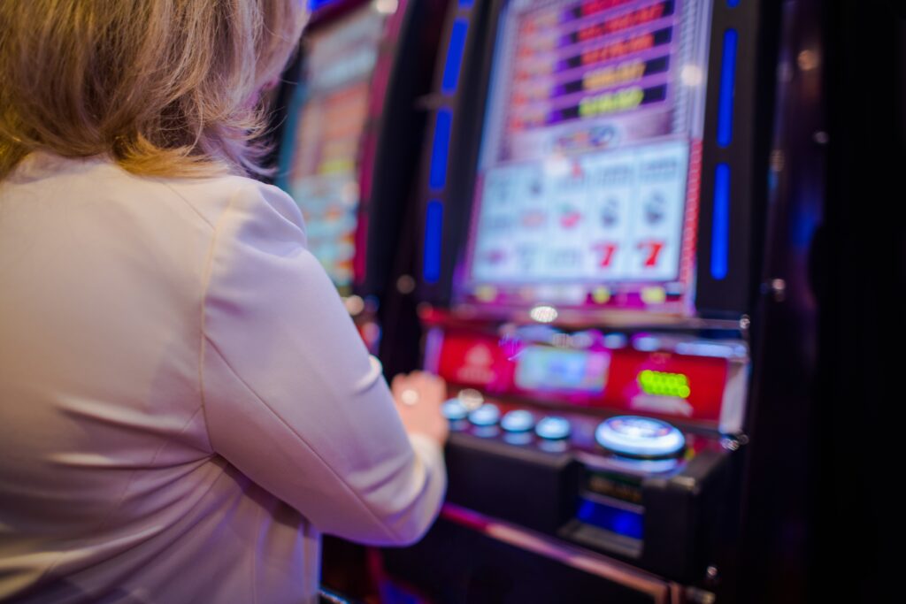 Woman playing on a slot machine.